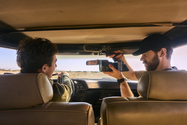 FX5 kamera ile hareket halindeki bir aracın yolcu koltuğundan sürücüyü çeken bir videografın kullanım görüntüsü.